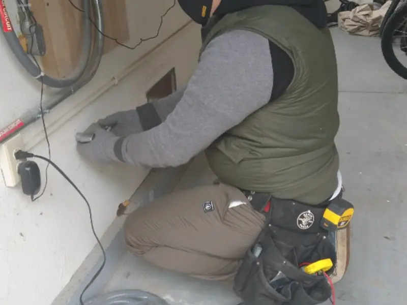 Electrician performing outlet wiring in a Lake Station garage